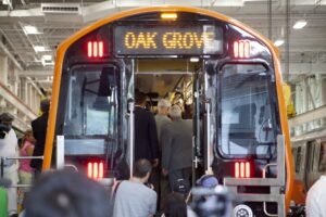 Members of the media and dignitaries examine the first of 152 Orange Line cars to arrive at the MBTA's Wellington yard at a public ceremony in mid-2019. State House News Service File Photo.