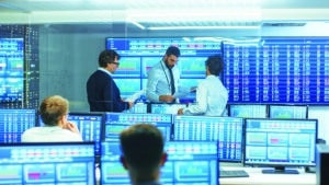 Three Experienced Stock Traders Talking Business, Consulting Documents and Argue About Data. They Work for a Big Stock Exchange Firm. Office is Full of Displays Showing Infographics and Numbers.