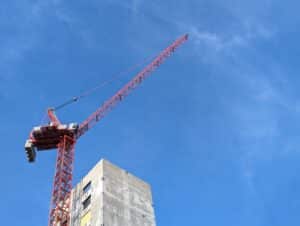 A construction crane in the seaport district is silhouetted against a blue sky