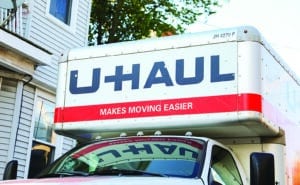 Boston, MA, USA, October, 7th 2023, U-Haul trucks lined up at sunset, symbolizing mobility, relocation, and adventure with rental vehicles parked under a vibrant sky